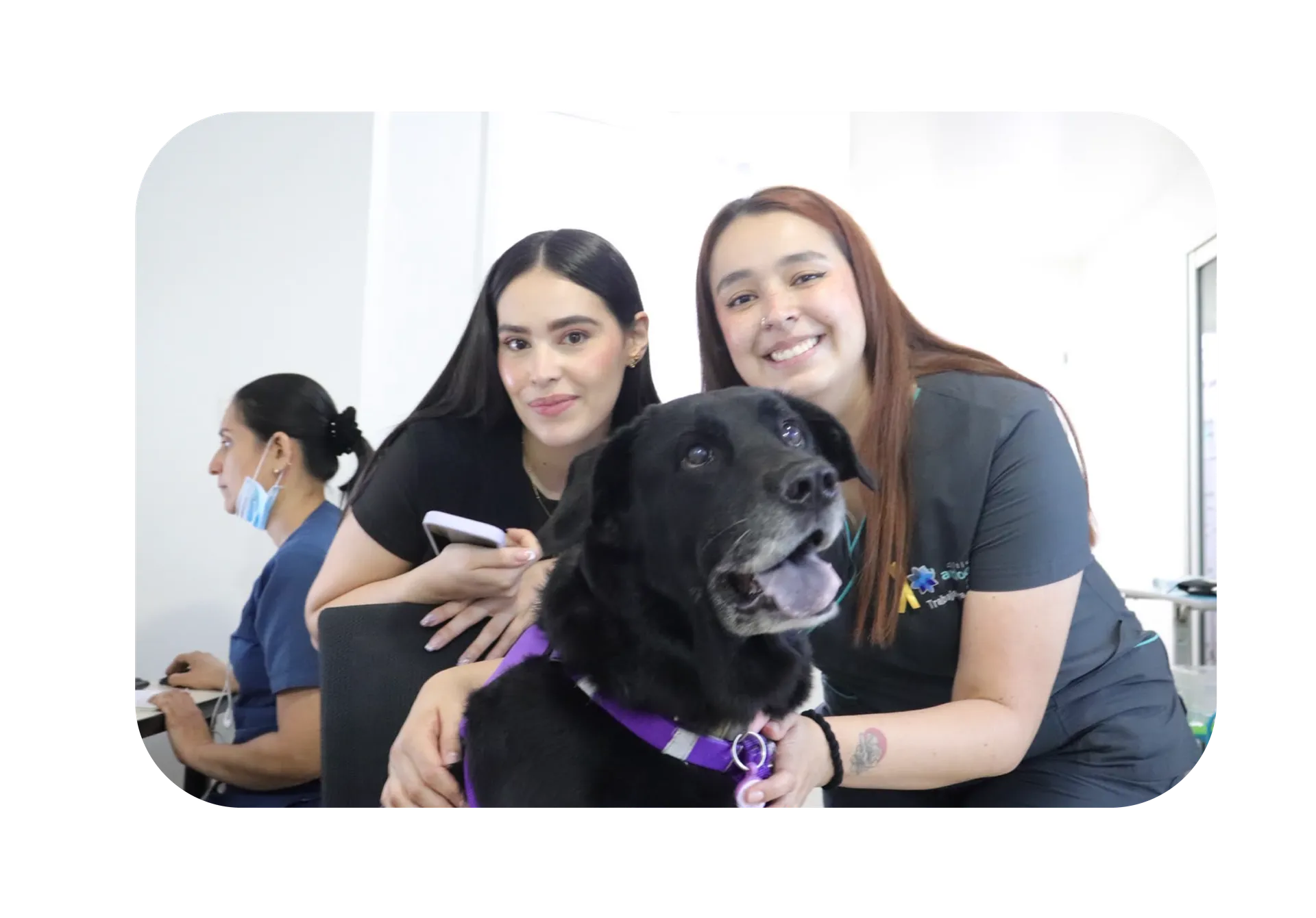 Dos colaboradoras de la Clínica con la perrita terapeuta